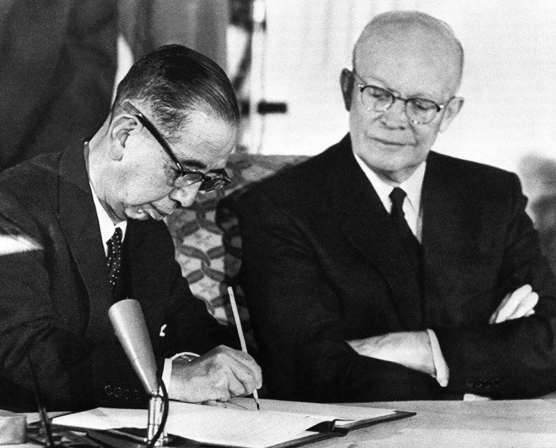 Japanese Prime Minister Nobusuke Kishi signs a treaty of mutual security with the United States on Jan. 19, 1960 in Washington. President Dwight D. Eisenhower witnesses the signing. (AP Photo)