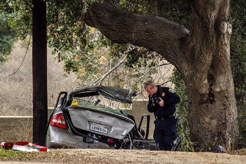 An officer with the California Highway Patrol on Monday investigates the scene of a deadly crash in the Temescal Valley, south of Corona, Calif.  