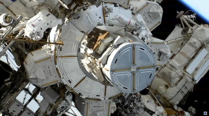 In this image take from NASA video, astronauts Christina Koch, left, moves away as Jessica Meir, right, exits a hatch as they prepare to install batteries for the International Space Station's solar power grid during a space walk, Monday, Jan. 20, 2020. (NASA via AP)