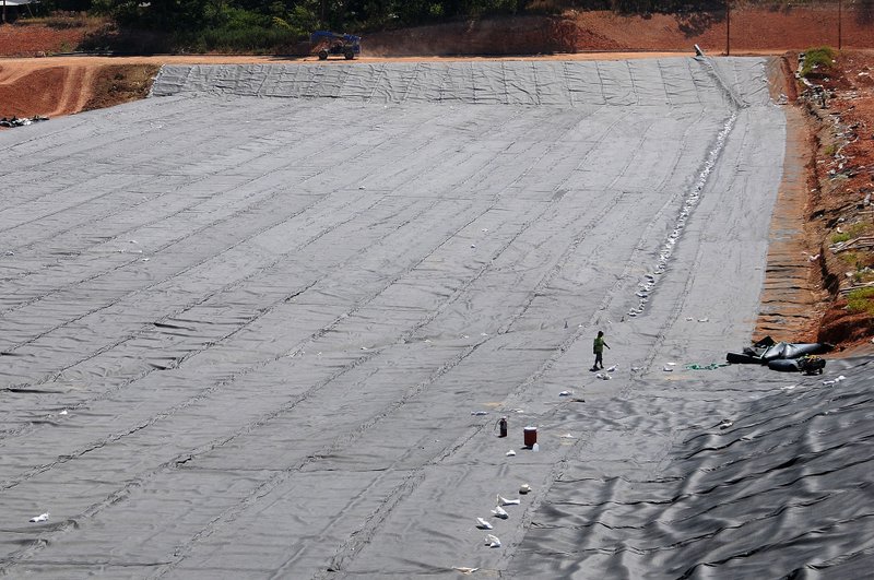 A construction worker walk across a construction site for a seven acre landfill at the Eco-Vista landfill Friday July 20, 2012 in Tontitown.