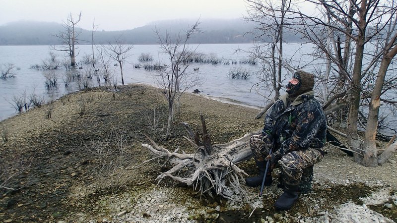 Alan Bland eyes a foggy sky for incoming mallards on Dec. 28 2019 during a duck hunt on Beaver Lake. High water and cold weather are the best conditions for waterfowl hunting at the reservoir.
(NWA Democrat-Gazette/Flip Putthoff)