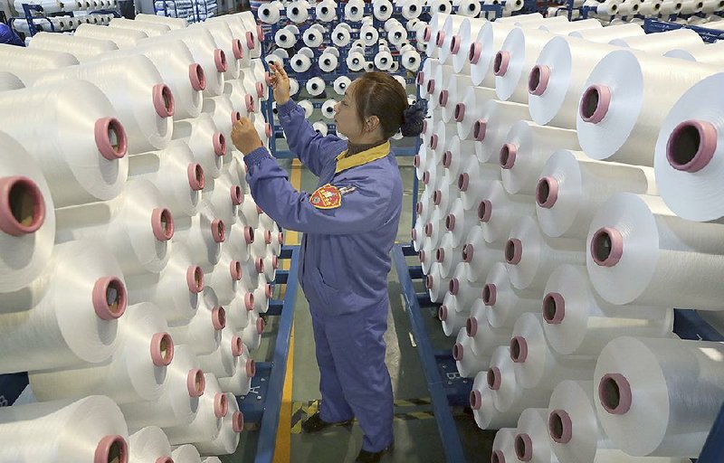 A woman works at a chemical fi ber plant Friday in Nantong, China. The International Monetary Fund predicts that China’s growth will slow from 6.1% in 2019 to 6% this year, while the global economy’s growth will accelerate from 2.9% to 3.3%.
(AP)