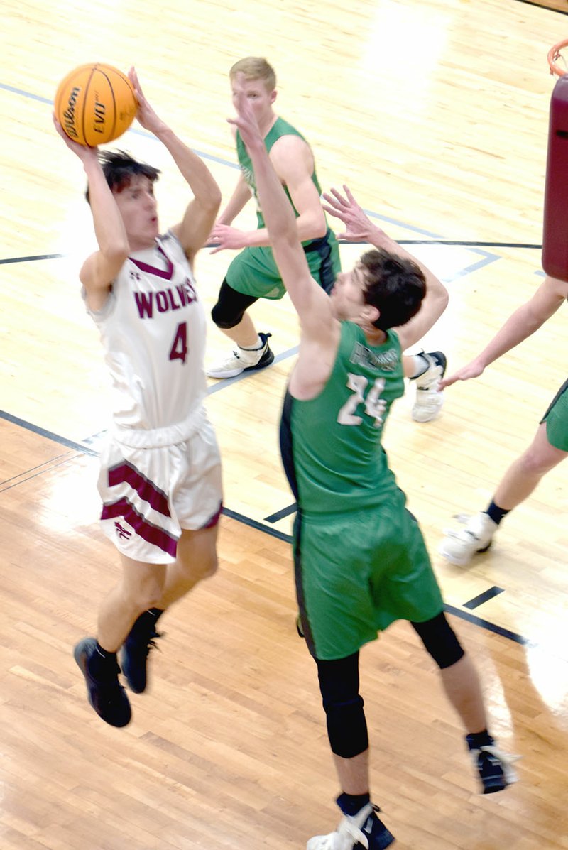 MARK HUMPHREY ENTERPRISE-LEADER Lincoln senior Chase Hutchens scores two of his four first-half points over the outstretched hands of Greenland's 6-6 Jack Quinn. The conference rivals battled it out on Friday at Wolfpack Arena as Lincoln celebrated Colors Day.