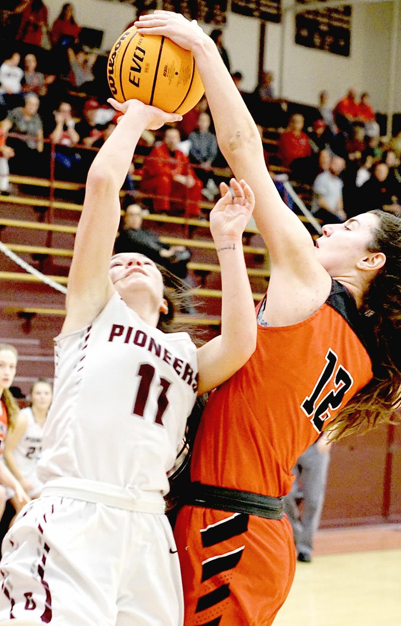 Westside Eagle Observer/RANDY MOLL Farmington junior Tori Kersey blocks a shot from Gentry's Ahrya Reding during play in Gentry on Jan. 14, 2020. The Lady Cardinals claimed a 61-36 victory.