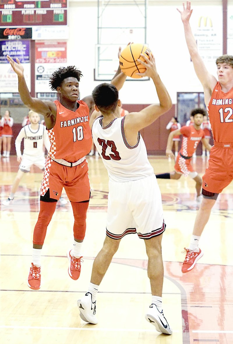 Westside Eagle Observer/RANDY MOLL Farmington seniors Marqwaveon Watson and Logan Landwehr put the full-court press on Brian Magana during play against Gentry High School in Gentry on Jan. 14. The Cardinals won 58-39.