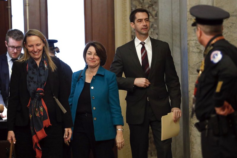 Sen. Amy Klobuchar, D-Minn., third from left, and Sen. Tom Cotton, R-Ark. fourth from left, arrive at the Capitol in Washington, Tuesday, Jan. 21, 2020. President Donald Trump's impeachment trial quickly burst into a partisan fight Tuesday as proceedings began unfolding at the Capitol. Democrats objected strongly to rules proposed by the Republican leader for compressed arguments and a speedy trial. (AP Photo/Julio Cortez)