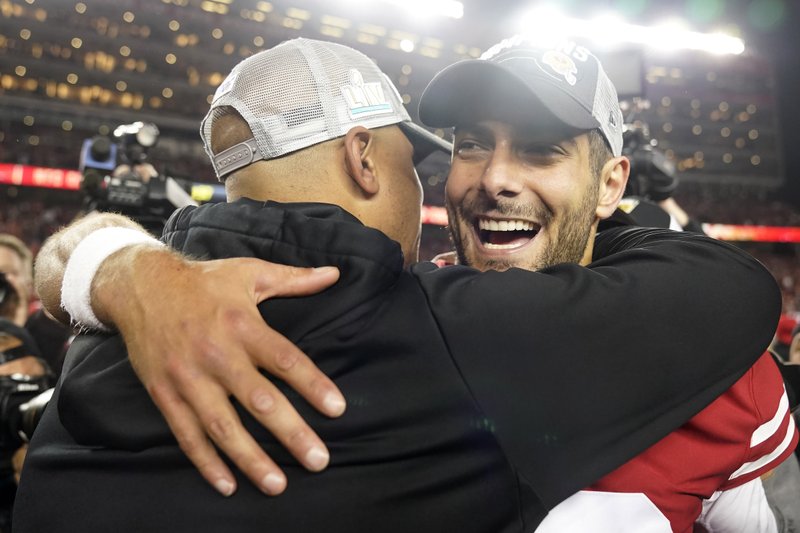 San Francisco 49ers quarterback Jimmy Garoppolo, right, celebrates with assistant coach Miles Austin after the NFL NFC Championship game against the Green Bay Packers Sunday in Santa Clara, Calif. The 49ers won 37-20 to advance to Super Bowl 54 against the Kansas City Chiefs. - Photo by Tony Avelar of The Associated Press