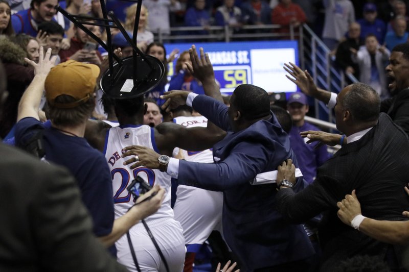 A fight between players spills into the crowd during the second half of an NCAA college basketball game between Kansas and Kansas State in Lawrence, Kan., Tuesday, Jan. 21, 2020. Kansas defeated Kansas State 81-59. (AP Photo/Orlin Wagner)
