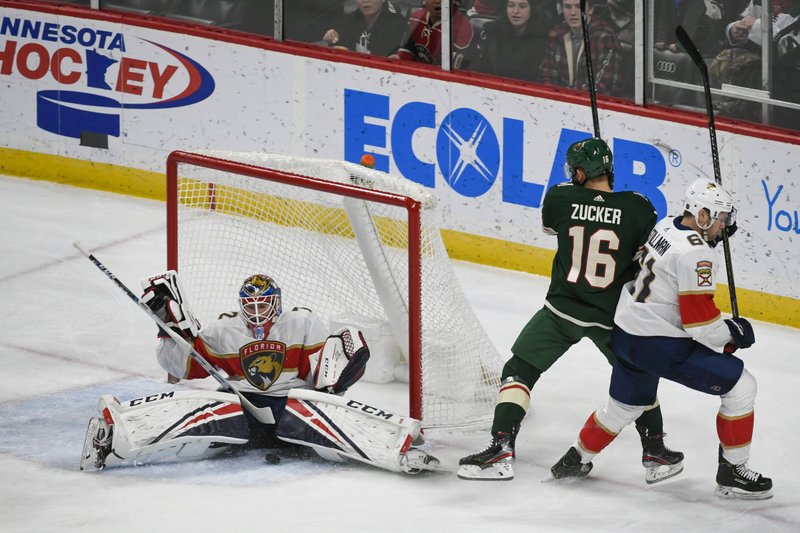 Florida Panthers goalie Sergei Bobrovsky, left, stops a shot by Minnesota Wild winger Jason Zucker (16) as Panthers defenseman Riley Stillman pushes Zucker past the goal during the first period of Monday's game in St. Paul, Minn. - Photo by Craig Lassig of The Associated Press