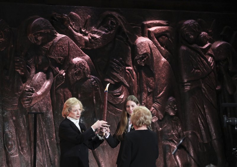 Israel Colette Avital (left), chairwoman of the Center Organizations of Holocaust Survivors, and fellow Holocaust survivor Rose Moskowitz (right) light a memorial torch during a ceremony Thursday in Jerusalem. More photos at arkansasonline.com/124jerusalem/.
(AP/Abir Sultan)