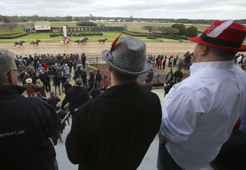 Fans watch the finish of the fourth race Friday during opening day at Oaklawn in Hot Springs. Approximately 20,000 fans showed up for the nine-race card. More photos online at arkansasonline.com/125oaklawn.