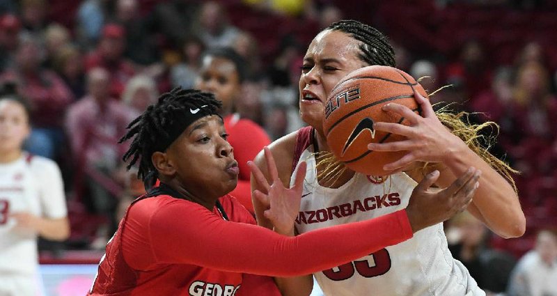Georgia’s Gabby Connally (left) defends a drive by Arkansas’ Chelsea Dungee during the Bulldogs’ victory over the No. 21 Razorbacks on Thursday night at Walton Arena in Fayetteville.
(NWA Democrat-Gazette/J.T. Wampler)