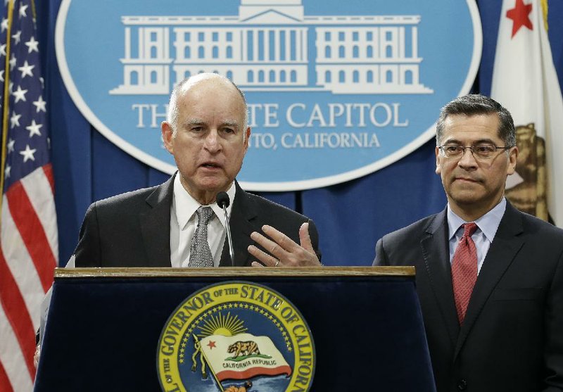 Former California Gov. Jerry Brown, left, accompanied by then California Attorney General Xavier Becerra, is shown on Wednesday, March 7, 2018, in Sacramento, Calif. 
(AP Photo/Rich Pedroncelli)