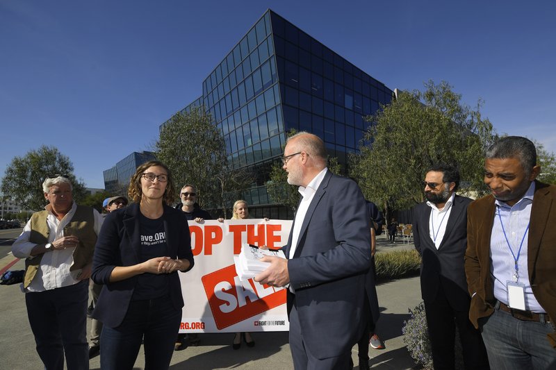 Maarten Botterman (center), chairman of the Internet Corp. for Assigned Names and Numbers, accepts a petition of more  than 35,000 signatures Friday in Los Angeles from protesters opposing  the proposed sale the dot.org online registry. More photos at arkansasonline.com/125org/
(AP/Mark J. Terrill)