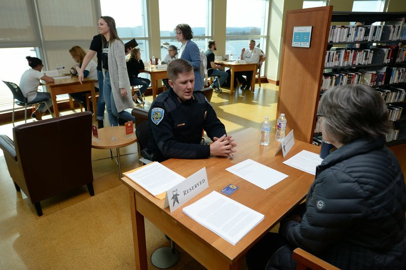 Kyle Jeney (center), a Fayetteville police officer, speaks Saturday with Leslie Spencer of Fayetteville at the library. The library created the second "Human Library of Fayetteville" where readers are able to "check out" one of 22 fellow residents to speak with them and learn about their life. Go to nwaonline.com/photos/ for today's photo gallery. (NWA Democrat-Gazette/Andy Shupe)