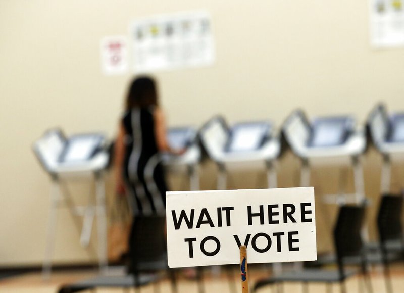 FILE - In this May 9, 2018, file photo, a woman votes in Sandy Springs, Ga. It's been more than three years since Russia's sweeping effort to interfere in U.S. elections through disinformation on social media, stolen campaign emails and attacks on voting systems. U.S. officials have made advances in trying to prevent similar attacks from undermining the 2020 vote, but challenges remain. (AP Photo/John Bazemore, File)