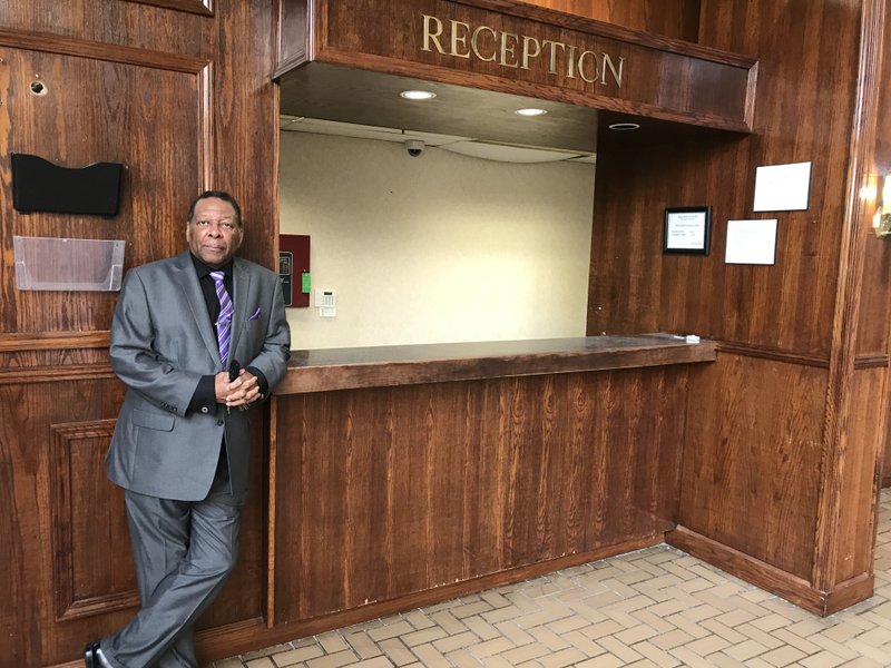 Joseph McCorvey, director of the Pine Bluff Convention Center, stands at the reception desk of the Plaza Hotel.