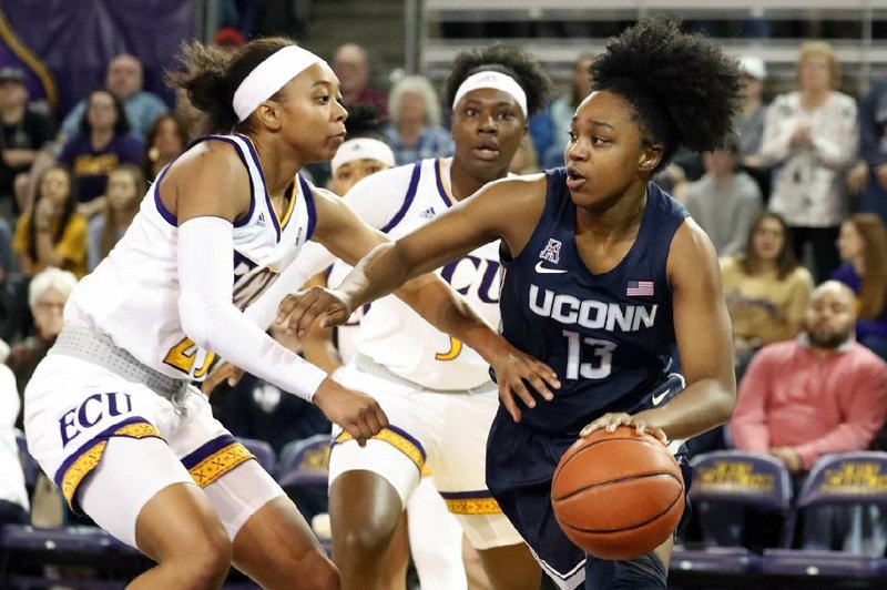 Former Central Arkansas Christian standout Christyn Williams (right) of Connecticut drives around East Carolina’s Ryann Evans during the first half Saturday in Greenville, N.C. Williams scored 26 points as the Huskies rolled 98-42.
(AP/Karl B DeBlaker)