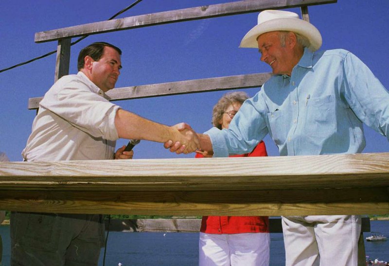 Arkansas Gov. Mike Huckabee (left) congratulates Ranger Boat Co. founder Forrest Wood on his appointment to the Arkansas Game and Fish Commission during a ceremony June 23, 1998. 