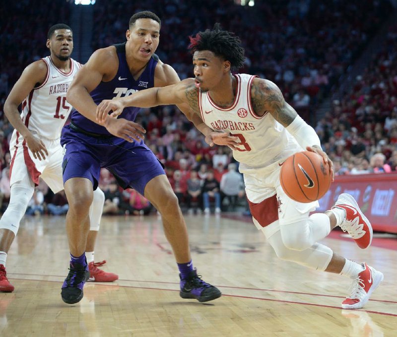 Arkansas guard Desi Sills (right) drives to the basket against TCU guard Desmond Bane during the second half of the Razorbacks’ 78-67 victory over the Horned Frogs on Saturday at Walton Arena in Fayetteville. Sills scored 18 points, his career high for a game at Walton Arena. More photos are available at arkansasonline.com/126hogs/.
(NWA Democrat-Gazette/Andy Shupe)