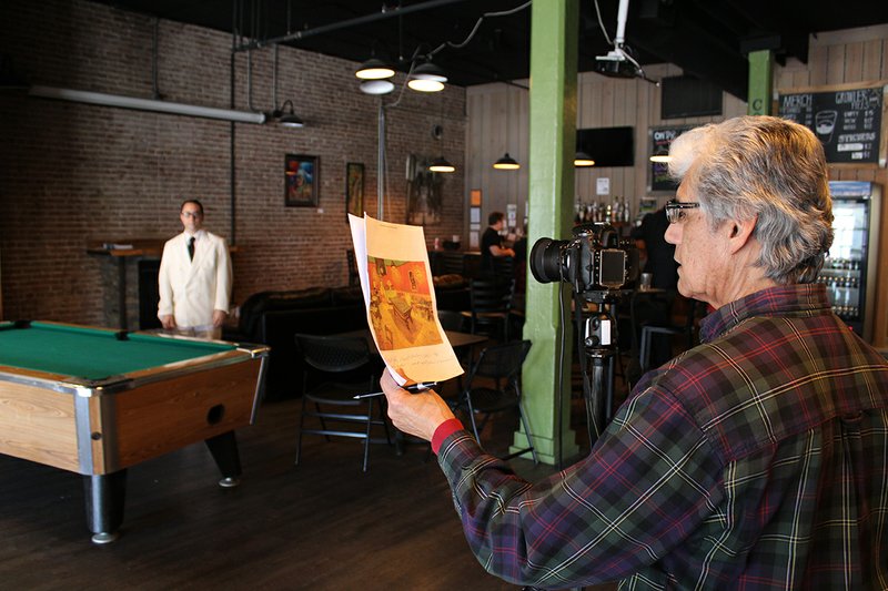 Photographer Eli Vega stages a recreation of Vincent van Gogh's "The Night Cafe" at Core Public House on Jan. 21 with Jason Nickerson-Tinna posing for the photo. This was the 10th of a planned 40-photograph series. - Photo by Tanner Newton of The Sentinel-Record