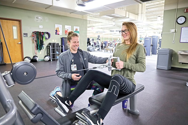 Erika Setzler, a fitness specialist with the Conway Regional Health and Fitness Center, advises Allison White on her form during a recent workout.