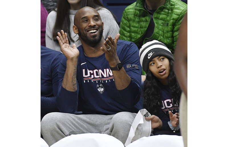 In this March 2, 2019 photo, Kobe Bryant and his daughter Gianna watch the first half of an NCAA college basketball game between Connecticut and Houston in Storrs, Conn. Bryant, the 18-time NBA All-Star who won five championships and became one of the greatest basketball players of his generation during a 20-year career with the Los Angeles Lakers, died in a helicopter crash Sunday, Jan. 26, 2020. Gianna also died in the crash. (AP Photo/Jessica Hill)