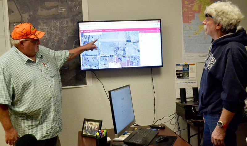 TIMES photograph by Annette Beard Pea Ridge Water/Wastewater Department inspector Mike Nida and department head Ken Hayes show the capabilities of the GIS program now accessible on the Water Department web site.