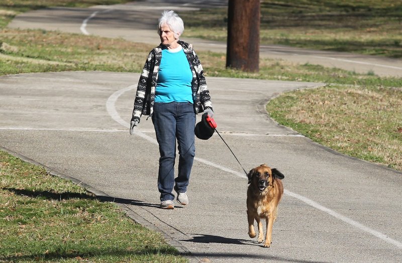A Hot Springs woman walks her dog on a leash along the Hot Springs Creek Greenway Trail in February. Photo by Richard Rasmussen of The Sentinel-Record