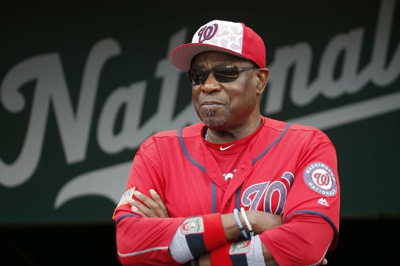 In this July 4, 2016, file photo,  Washington Nationals manager Dusty Baker (12) stands in the dugout before a baseball game against the Milwaukee Brewers at Nationals Park in Washington. A person with knowledge of the negotiations said Tuesday, Jan. 28, 2020, that Baker, 70,  is working to finalize an agreement to become manager of the Houston Astros. 
(AP Photo/Alex Brandon, File)