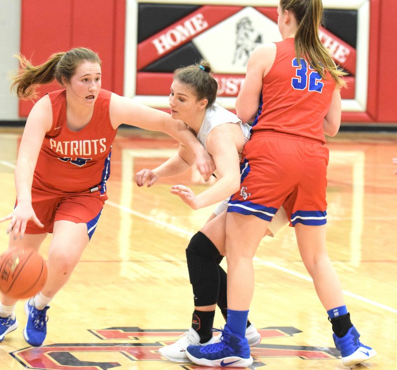 RICK PECK/SPECIAL TO MCDONALD COUNTY PRESS McDonald County's Caitlyn Barton tries to get past a pick by East Newton's Katie Kester (32) while guarding Kaitlyn Hailey during the Lady Mustangs 44-35 loss on Jan. 23 at MCHS.