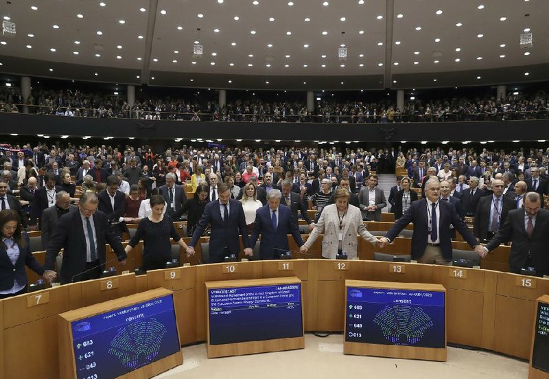 European Parliament members hold hands and sing during Wednesday’s session in Brussels after the vote approving terms of Britain’s exit from the European Union after 47 years. The departure will be official Friday, but the United Kingdom will continue with EU economic arrangements until the end of the year.
(AP/Yves Herman)