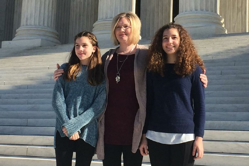 Kendra Espinoza of Kalispell, Mont., (center) stands with her daughters Naomi and Sarah outside the U.S. Supreme Court in Washington. Espinoza is the lead plaintiff in a case the court heard Jan. 22 that could make it easier to use public money to pay for religious schooling in many states.