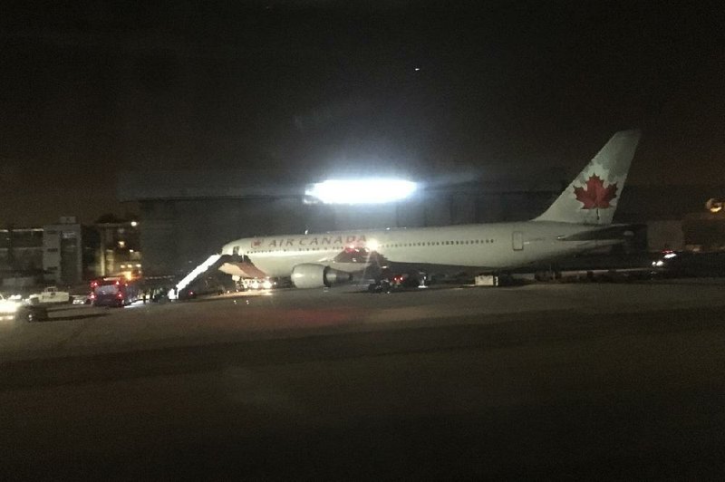 The Air Canada plane is parked Monday at the airport in Madrid after making an emergency landing. 