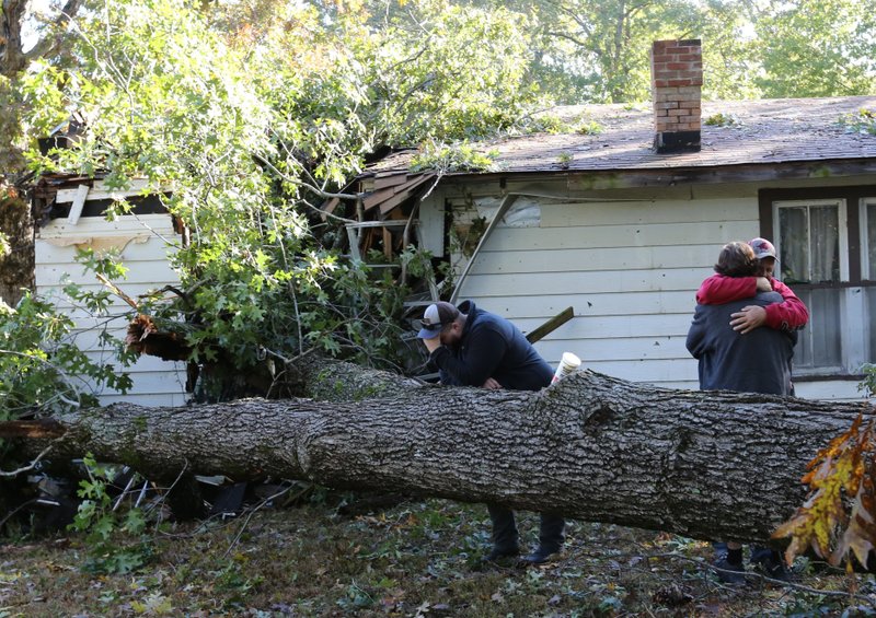 Relatives grieve Monday after a man was killed when a tree fell on his Benton County home during a heavy storm on Oct. 21, 2019. Meteorologists received reports that multiple tornadoes might have touched down as the storm system crossed the state. More photos are available at arkansasonline.com/1022storm/ 