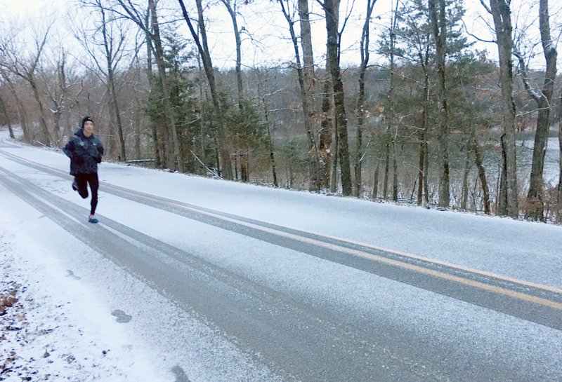 In this Jan. 2020 file photo, Jeremy Morgan of the Rogers area runs along a county road in the Rocky Branch area near Beaver Lake. (NWA Democrat-Gazette/Flip Putthoff)