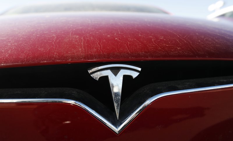 FILE - In this Feb. 2, 2020, file photo, the company logo shines on the grille of an unsold 2020 Model X at a Tesla dealership in Littleton, Colo. Tesla is now worth more than General Motors, Ford and Fiat Chrysler combined, even though the Big Three together sell more cars and trucks in two weeks than Tesla does in a whole year. (AP Photo/David Zalubowski, File)