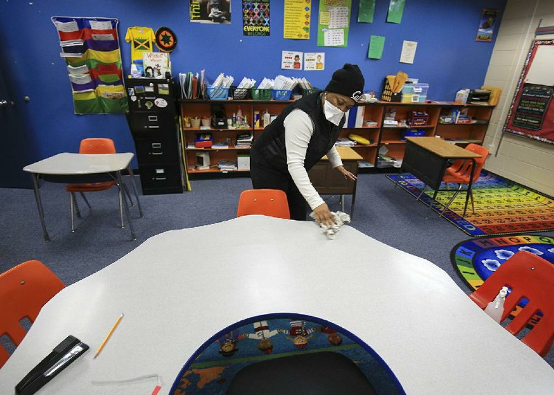 Principal Shoutell Richardson helps disinfect a classroom Tuesday at Rockefeller Elementary and Early Childhood Center in Little Rock. The school, along with Dr. Martin Luther King Jr. Elementary School in Little Rock, was closed for disinfecting and to prevent further spread of the flu.
(Arkansas Democrat-Gazette/Staton Breidenthal)