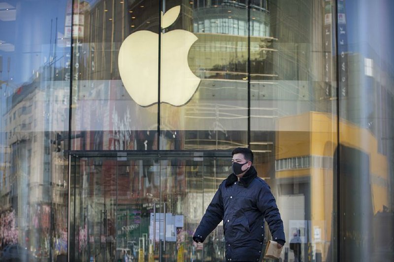 A man in Beijing walks Tuesday past an Apple store that is temporarily closed because of the coronavirus outbreak. Apple contractors in China have delayed reopening factories that closed for the Lunar New Year holiday.
(AP/Mark Schiefelbein)