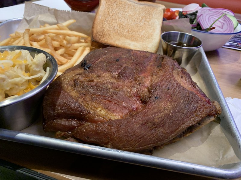 The end of a slab of ribs, a half rack, provides extra meat for one of The Library Kitchen + Lounge's three Meat and Three options, with sides of (clockwise from left) mac and cheese, shoestring fries and a side salad.
(Arkansas Democrat-Gazette/Eric E. Harrison)