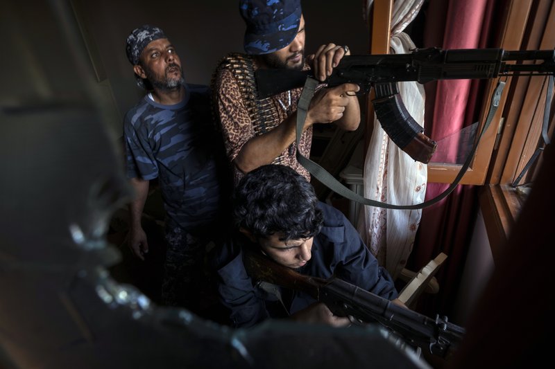 FILE - In this Aug 31, 2019 file photo, fighters of the 'Shelba' unit, a militia allied with the U.N.-supported Libyan government, aim at enemy positions at the Salah-addin neighborhood front line in Tripoli, Libya. Two Libyan militia commanders and a Syrian war monitor group say Turkey is deploying Syrian extremists to fight in Libya's civil war. (AP Photo/Ricard Garcia Vilanova, File)
