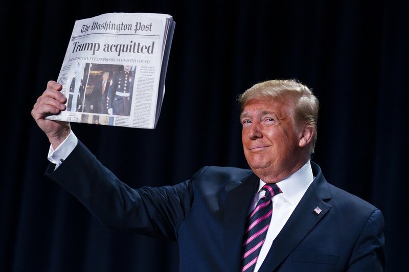 President Donald Trump holds up a newspaper with the headline that reads "Trump acquitted" during the 68th annual National Prayer Breakfast, at the Washington Hilton, Thursday, Feb. 6, 2020, in Washington.


