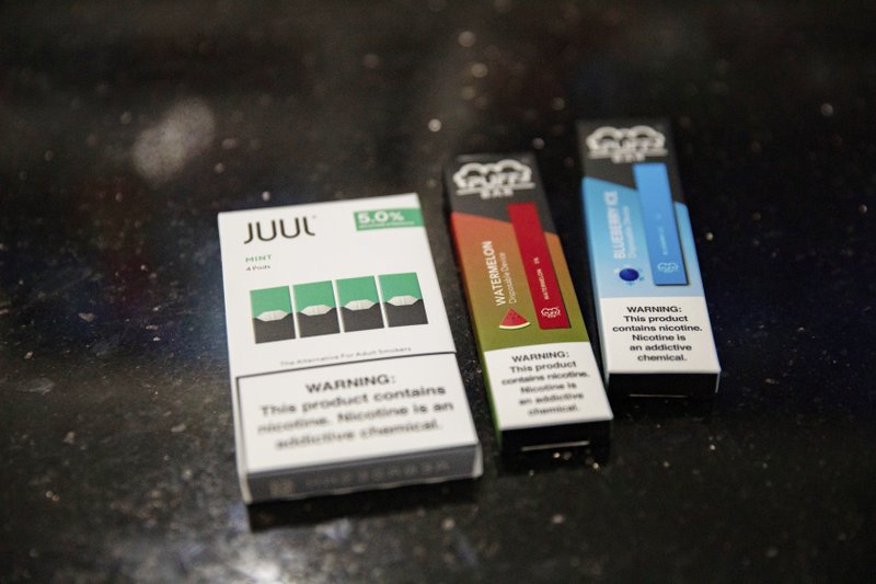 This Jan. 31, 2020 photo shows mint Juul pods next to Puff Bar flavored disposable vape devices at a store in the Brooklyn borough of New York. On Thursday, Feb. 6, 2020, the U.S. government began enforcing restrictions on flavored electronic cigarettes&#xa0;aimed at curbing underage vaping. But parents, researchers and students warn that some young people have already moved on to a newer kind of vape that isn't covered by the flavor ban - disposables. (AP Photo/Marshall Ritzel)