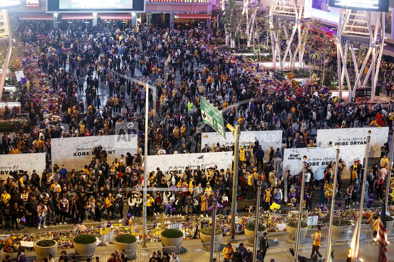 In this Jan. 31, 2020, file photo, fans gather at a memorial for Kobe Bryant in front of Staples Center, prior to an NBA game between the Los Angeles Lakers and the Portland Trail Blazers in Los Angeles. A person with knowledge of the details says a public memorial service for Bryant, his daughter and seven others killed in a helicopter crash is planned for Feb. 24 at Staples Center. The Los Angeles arena is where Bryant starred for the Lakers for most of his two-decade career. The date corresponds with the jersey numbers he and 13-year-old daughter Gianna wore, 24 for him and 2 for her. (AP Photo/Ringo H.W. Chiu, File)