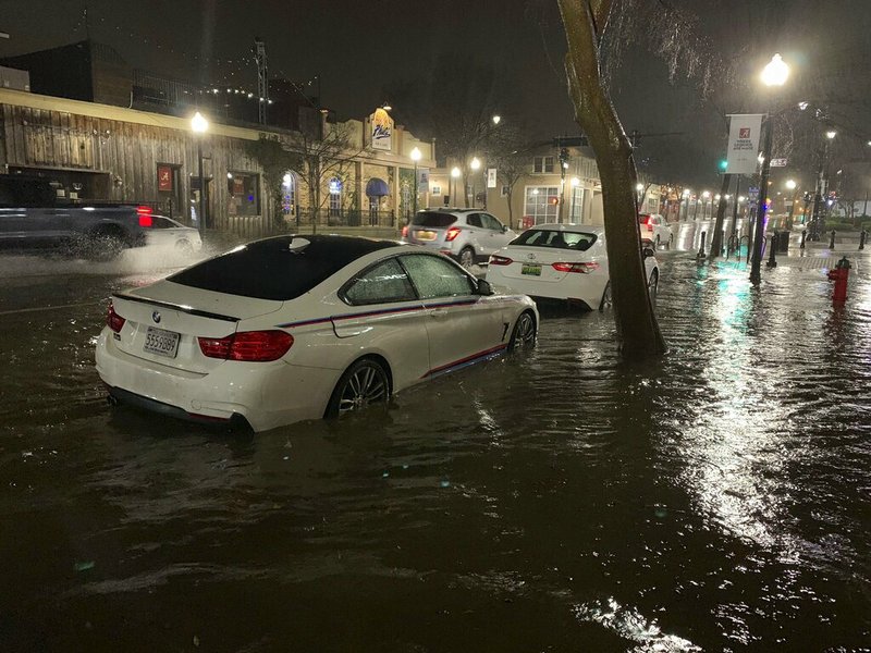 In this photo released by Adam Fowler, vehicles sit parked in on the side of a main road in floodwater, Wednesday, Feb. 6, 2020, in Tuscaloosa, Alabama.