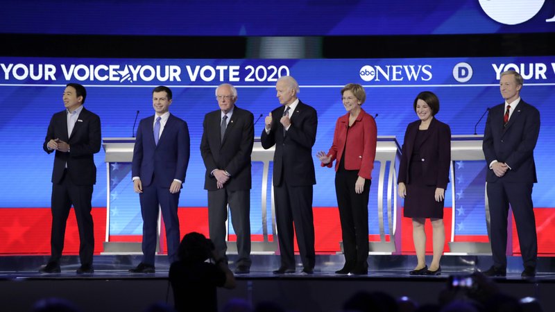 From left, Democratic presidential candidates entrepreneur Andrew Yang, former South Bend Mayor Pete Buttigieg, Sen. Bernie Sanders, I-Vt., former Vice President Joe Biden, Sen. Elizabeth Warren, D-Mass., Sen. Amy Klobuchar, D-Minn., and businessman Tom Steyer stand on stage Friday, Feb. 7, 2020, before the start of a Democratic presidential primary debate hosted by ABC News, Apple News, and WMUR-TV at Saint Anselm College in Manchester, N.H. (AP Photo/Charles Krupa)