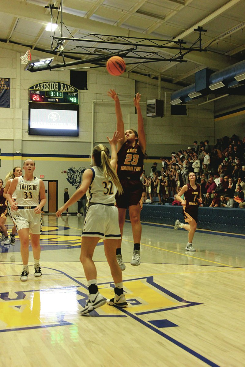 Lake Hamilton sophomore Hayleigh Wyrick (23) puts up a shot over Lakeside junior Maddie Trusty (32) while sophomore Ronni Formby (33) looks on in Friday&#x2019;s game at Lakeside Athletic Complex. - Photo by James Leigh of The Sentinel-Record