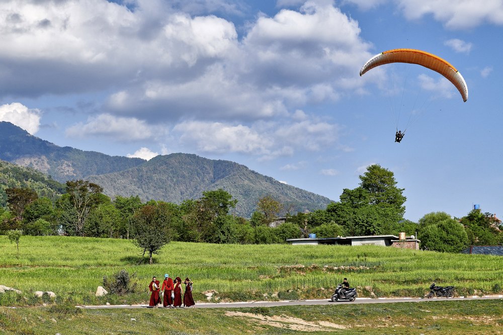 Des moines marchent près d'un site d'atterrissage de parapente à Bir dans l'Himachal Pradesh, en Inde, où le paysage rend l'activité de haut vol très populaire.  (Le New York Times/Poras Chaudhary)