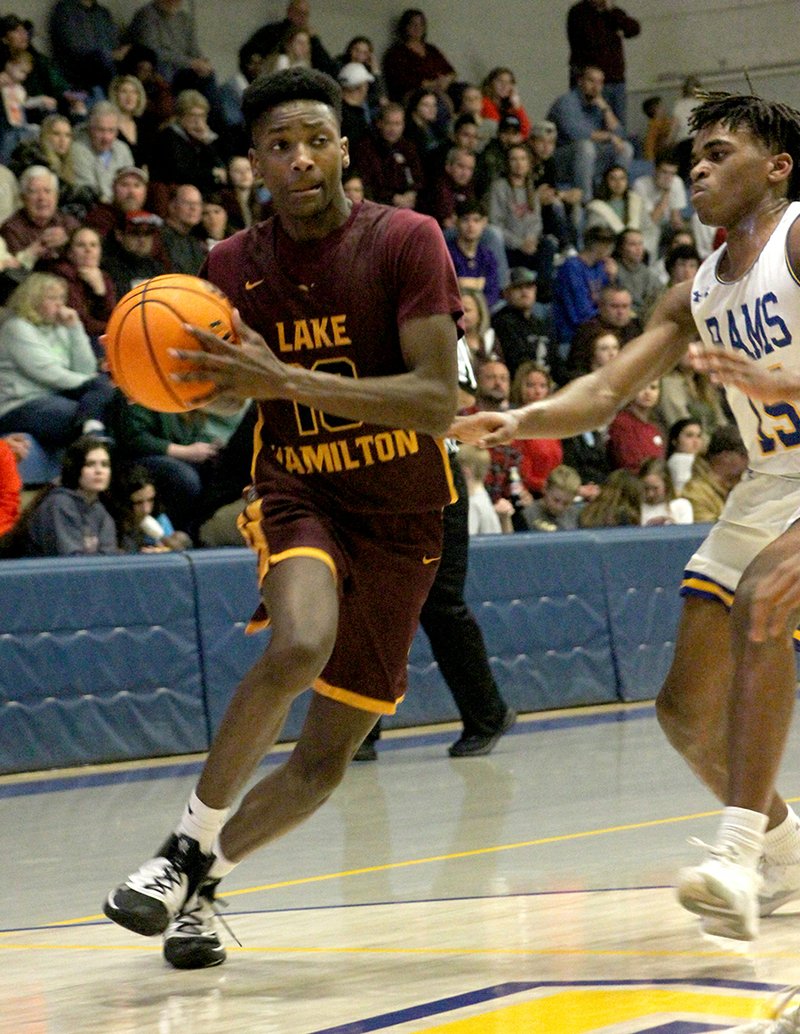 Lake Hamilton senior Malique Hill (10) drives in to the rim as Lakeside sophomore Alveon Harris (15) defends in Friday's game at Lakeside Athletic Complex. - Photo by James Leigh of The Sentinel-Record