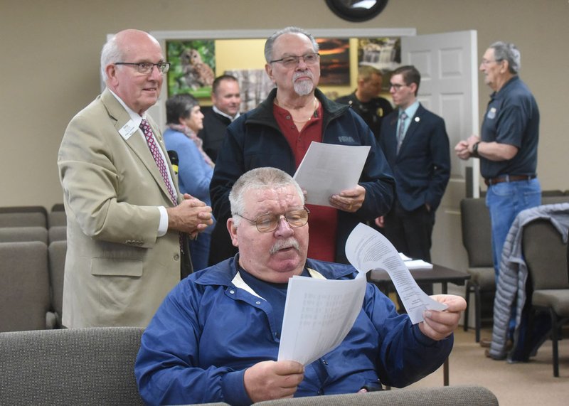 Jim Wozniak (center), a former Bella Vista police chief, studies Wednesday information about a 1% sales tax and bond issue on the March 3 primary election ballot in Bella Vista. Mayor Peter Christie (left) chats with Ray Gott (center) before a town hall meeting at council chambers about the election. The city wants to replace Fire Station No. 3 and also build a public safety facility to house the Police Department, a police and fire dispatch center and a courtroom. Go to nwaonline.com/200206Daily/ for today's photo gallery. (NWA Democrat-Gazette/Flip Putthoff)